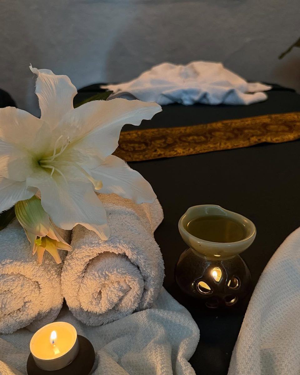 Stillleben mit Lilie, Handtüchern und Aroma-Diffusor im Behandlungsraum